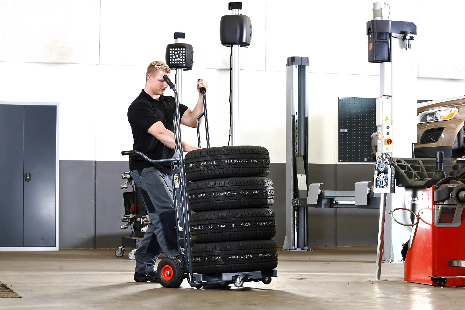 Mitarbeiter kippt einen Reifenstapel mit dem Wheel Caddy aus der senkrechten Position