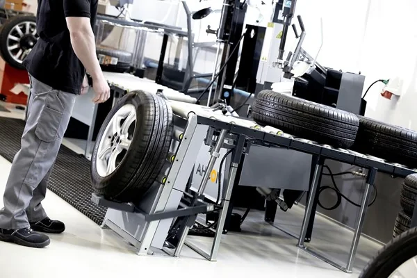 Werkstattmitarbeiter führt ein Komplettrad dem AHCON Wheel Lift WL 900 zu
