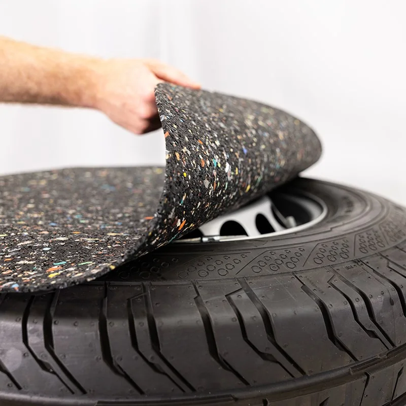 Hand hebt eine AHCON Anti-Slip Schutzmatte von einem Komplettrad ab
