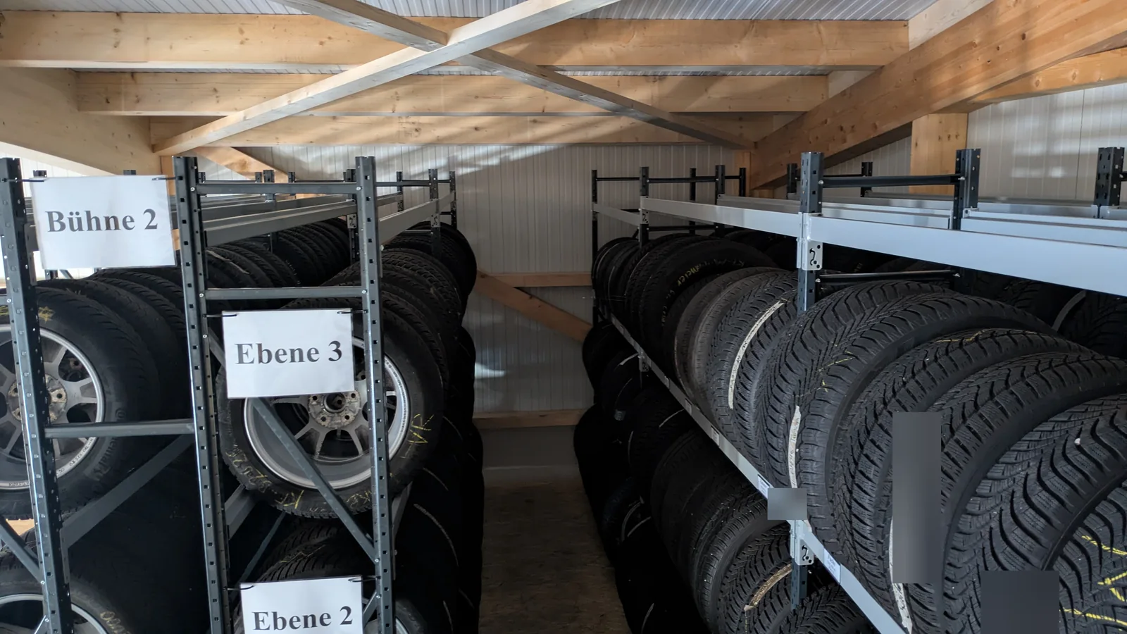 Individuelle Regalhöhen für Degenharts vorhandene Lagerbühne AHCON F1-Räderregale auf der Lagerbühne bei Degenhart unter einer niedrigen Dachkonstruktion