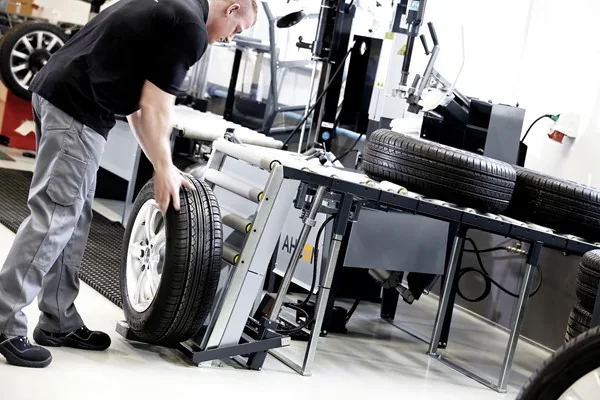 Werkstattmitarbeiter positioniert ein Komplettrad auf dem Wheel Lift WL 900