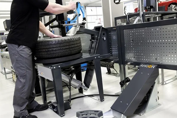 Werkstattmitarbeiter drückt einen Reifen mit dem AHCON BBRT 700 horizontal ab