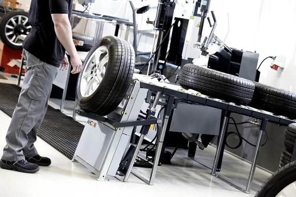 Angehobenes Komplettrad am AHCON Wheel Lift WL 900 vor der Rollenbahn